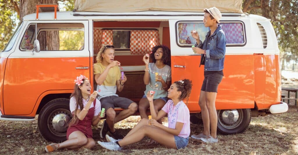 Happy friends enjoying at camper van
